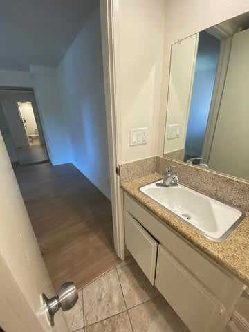 A bathroom with a sink, mirror, and a toilet.