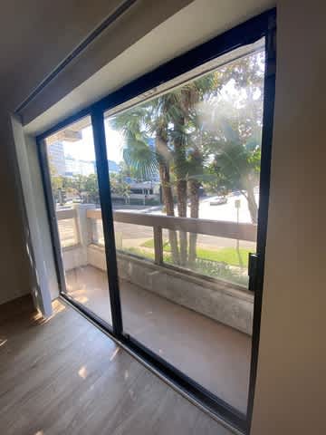 A view of a balcony through a sliding glass door.
