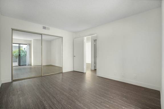 A large empty room with a wooden floor and white walls.