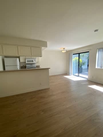 A kitchen with a refrigerator, microwave, and oven.
