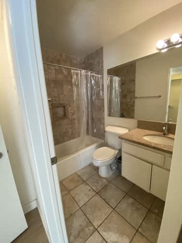 A bathroom with a toilet, sink, and shower.