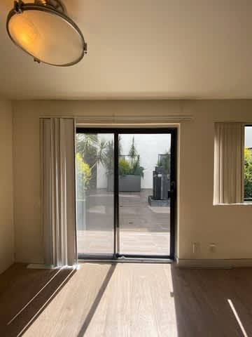 A room with a sliding glass door leading to a balcony.