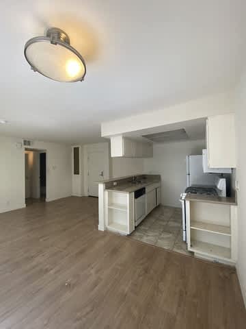 A kitchen with a refrigerator, stove, and sink.