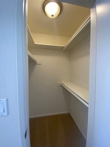 A white hallway with a light on the ceiling.