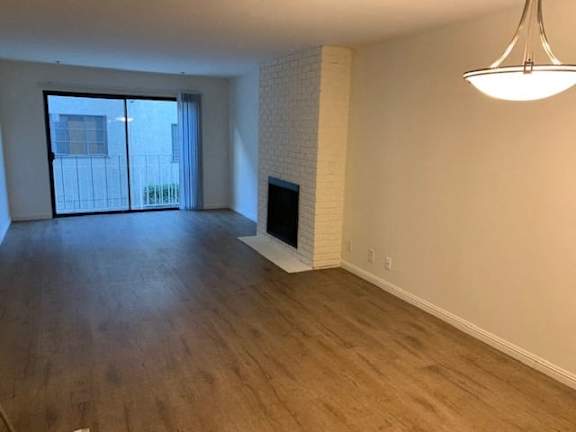 A room with a fireplace and a window with a view of a building outside.