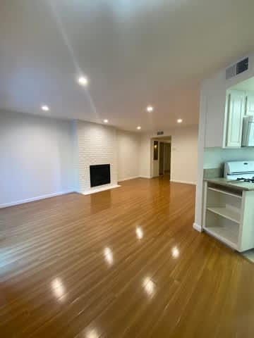 A room with a fireplace and wooden floors.
