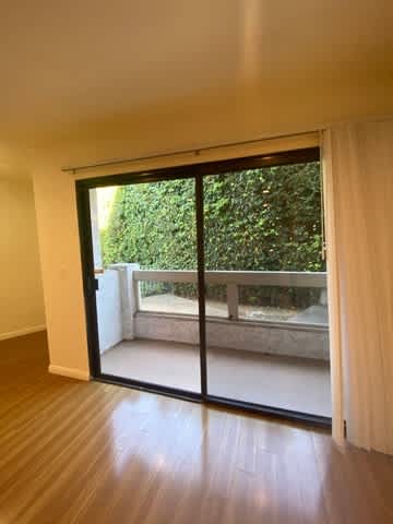 A room with a sliding glass door leading to a balcony.