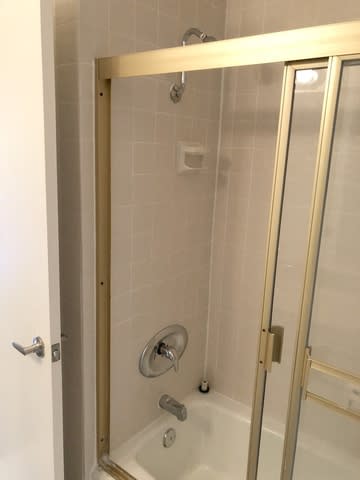A shower stall with a glass door and a shower head.