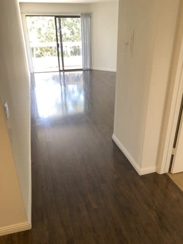 A hallway with wood floors and white walls.