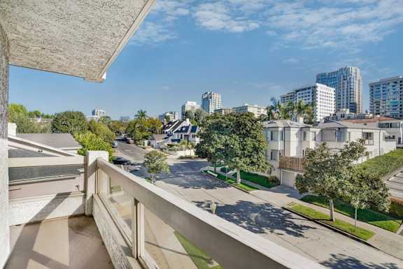 A view from a balcony overlooking a residential street.