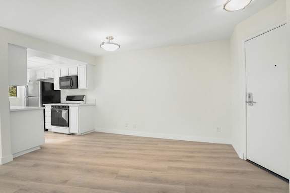 A kitchen with a refrigerator, microwave, and oven is visible.