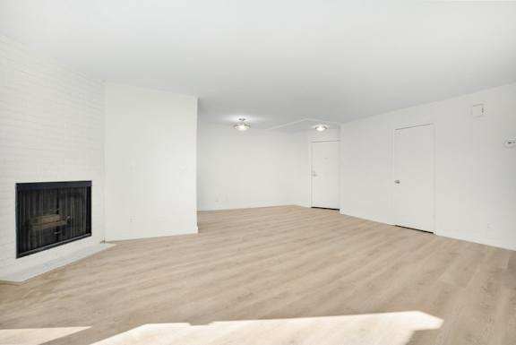 A large, empty room with a fireplace on the left side.