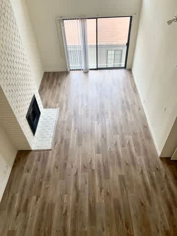 A room with wooden flooring and a television.