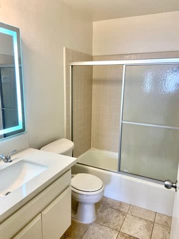 A white toilet sits next to a sink in a bathroom.