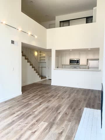 A kitchen with a staircase leading to the upper floor.