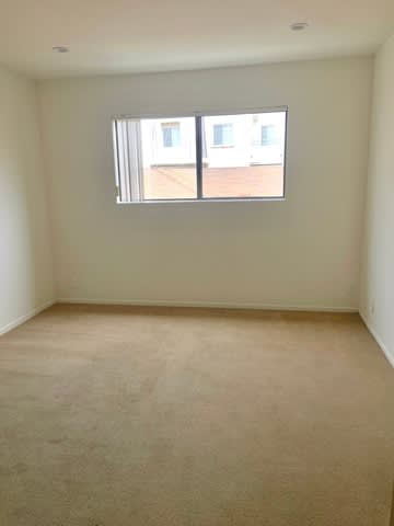 A room with a carpeted floor and a window.