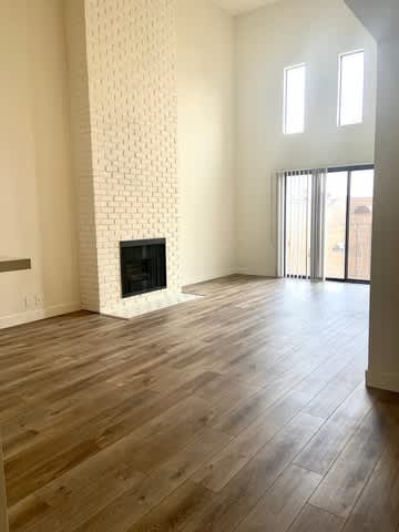 A room with a fireplace and wooden floors.