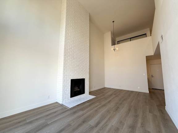 A room with a fireplace and wood flooring.