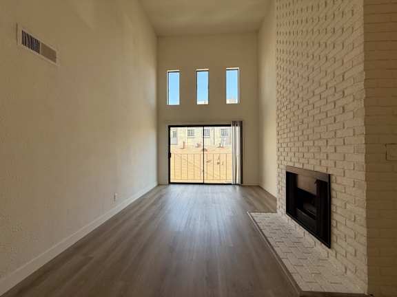 A room with a fireplace and wooden floors.
