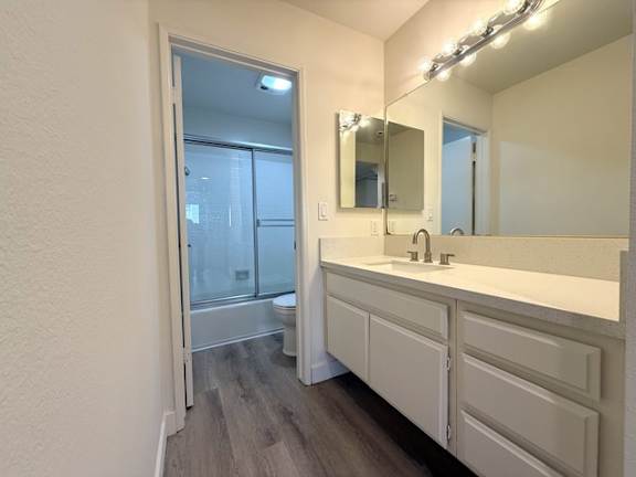 A bathroom with a sink, mirror, and a glass door shower.