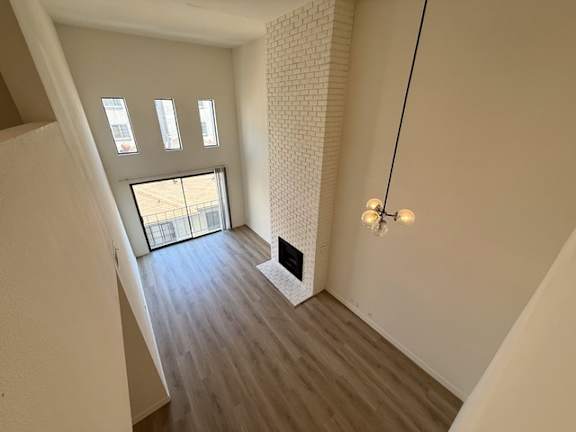 A room with a wooden floor and a white brick wall.