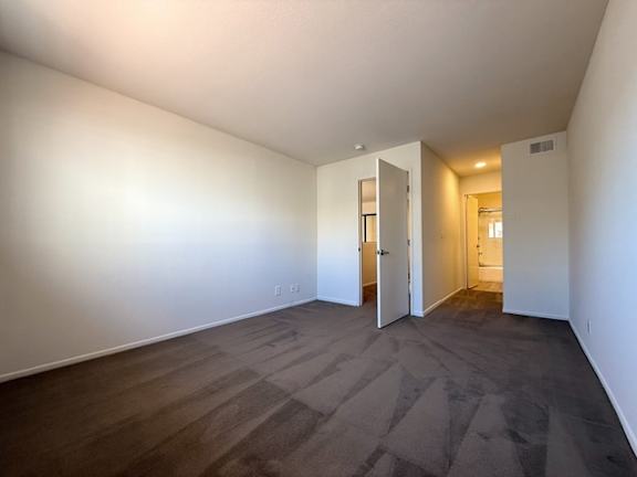 A room with a carpeted floor and white walls.