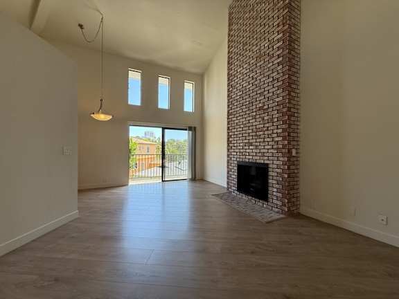 A room with a fireplace and a view of a building outside the window.