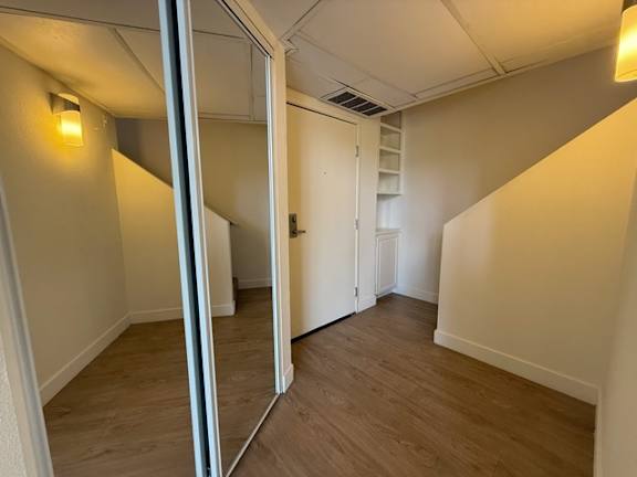 A hallway with a mirror on the left side.