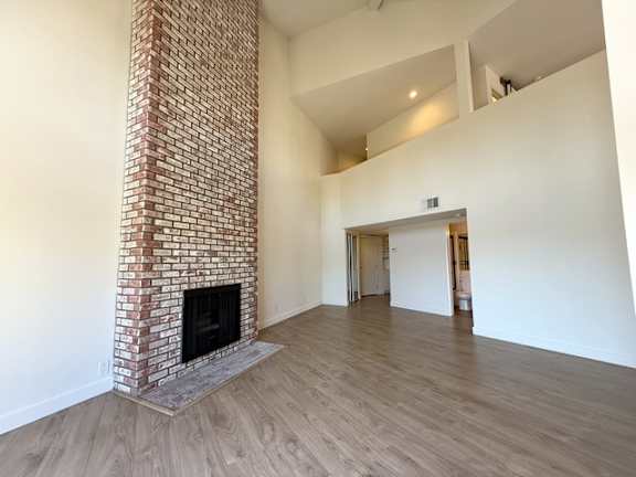 A room with a fireplace and wooden floors.
