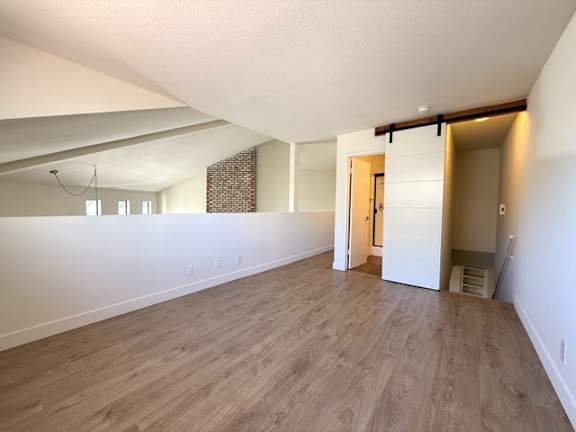 A room with wooden flooring and white walls.