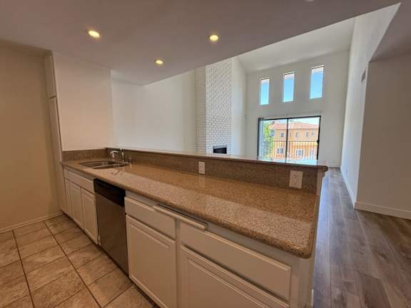 A kitchen with a sink, countertop, and cabinets.