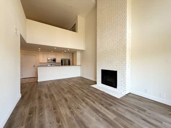 A modern living room with a fireplace and wooden flooring.