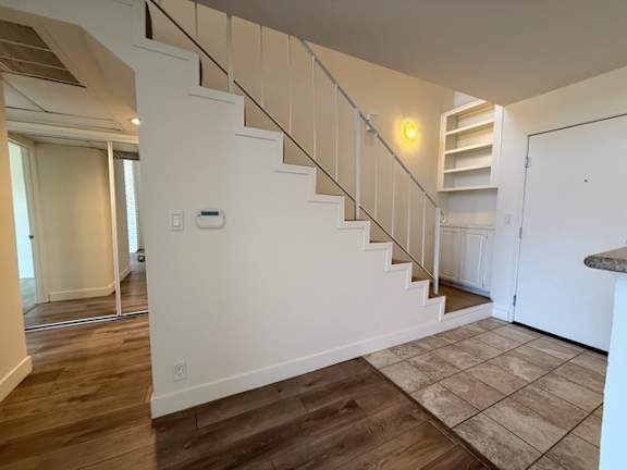 A staircase with a light on the wall.