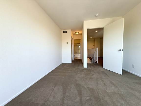 A room with a carpeted floor and white walls.