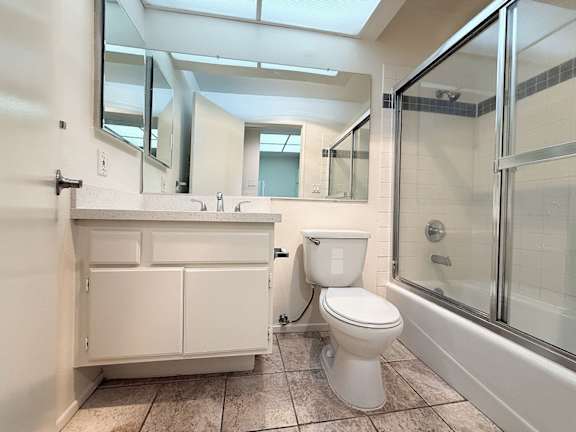 A white toilet is in a bathroom with a walk-in shower.