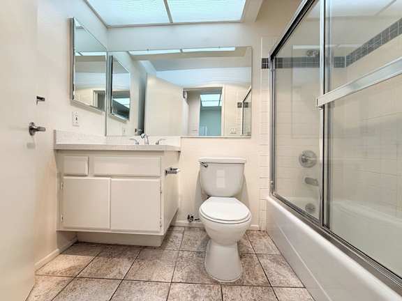 A white toilet sits in a bathroom with a walk-in shower.