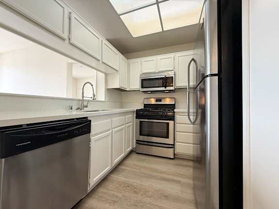 A kitchen with white cabinets and stainless steel appliances.