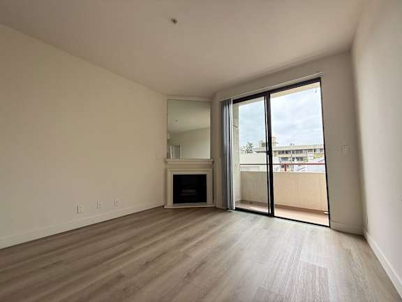 A spacious room with a fireplace and sliding glass doors.