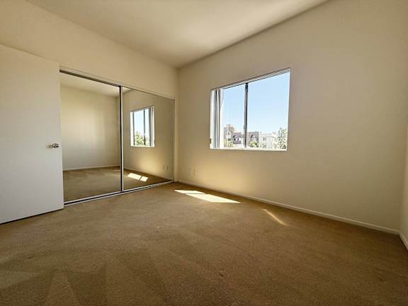 A room with a carpeted floor and a large window.