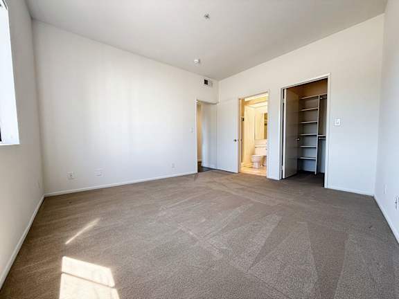 A large empty room with a carpeted floor and white walls.