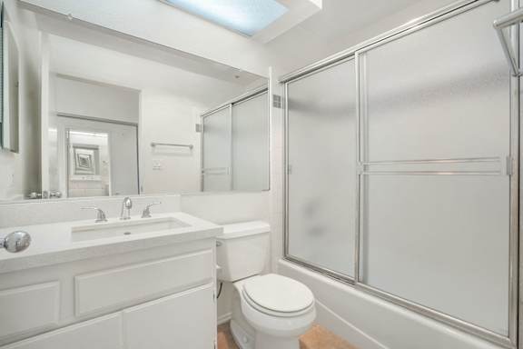 A white bathroom with a toilet, sink, and shower.