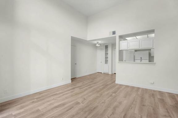 A room with wooden flooring and white walls.