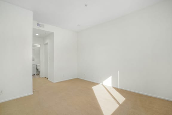 A room with white walls and a light brown floor.