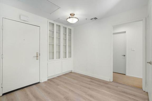 A room with white walls and a wooden floor.