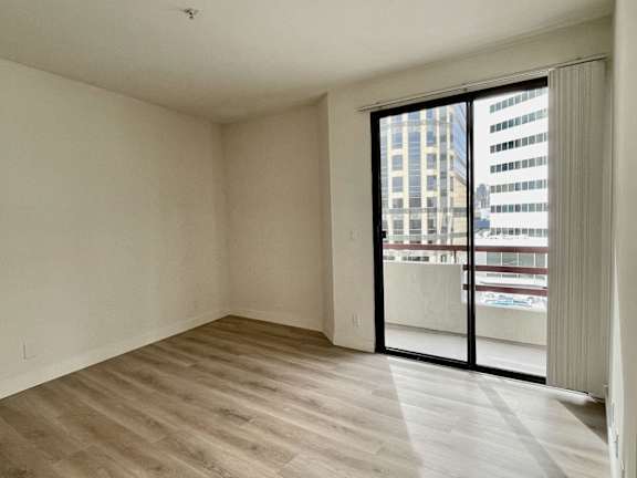 A room with a sliding glass door leading to a balcony.
