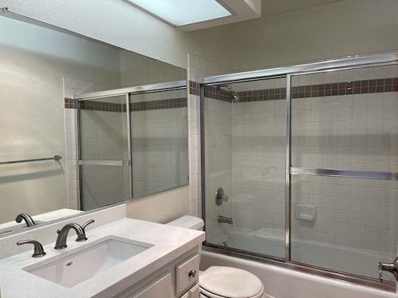 A bathroom with a sink, toilet, and shower.