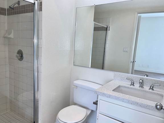 A white toilet sits next to a sink in a bathroom.
