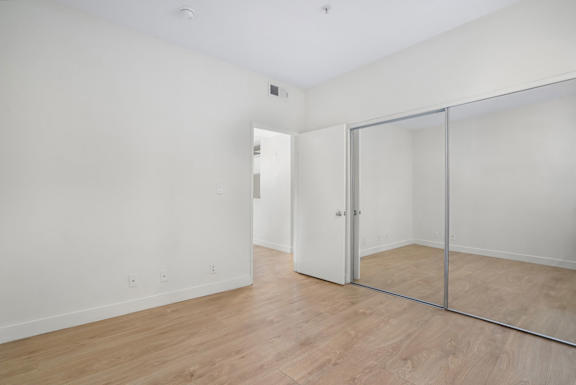 A room with a sliding glass door and wood flooring.