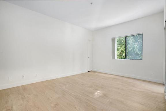 Empty room with wooden floor and a window.