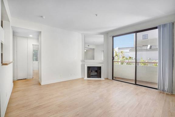 A spacious living room with a fireplace and sliding glass doors.